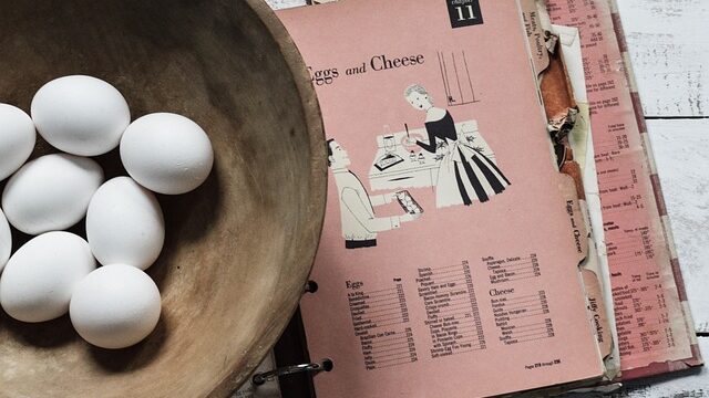 ボウルに入った沢山の卵とレシピ本が置いてある画像