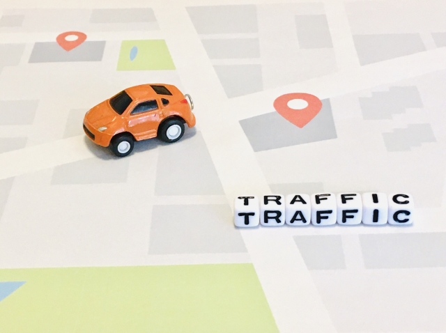 地図の上に車のおもちゃと「TRAFFIC」の文字が書かれた画像